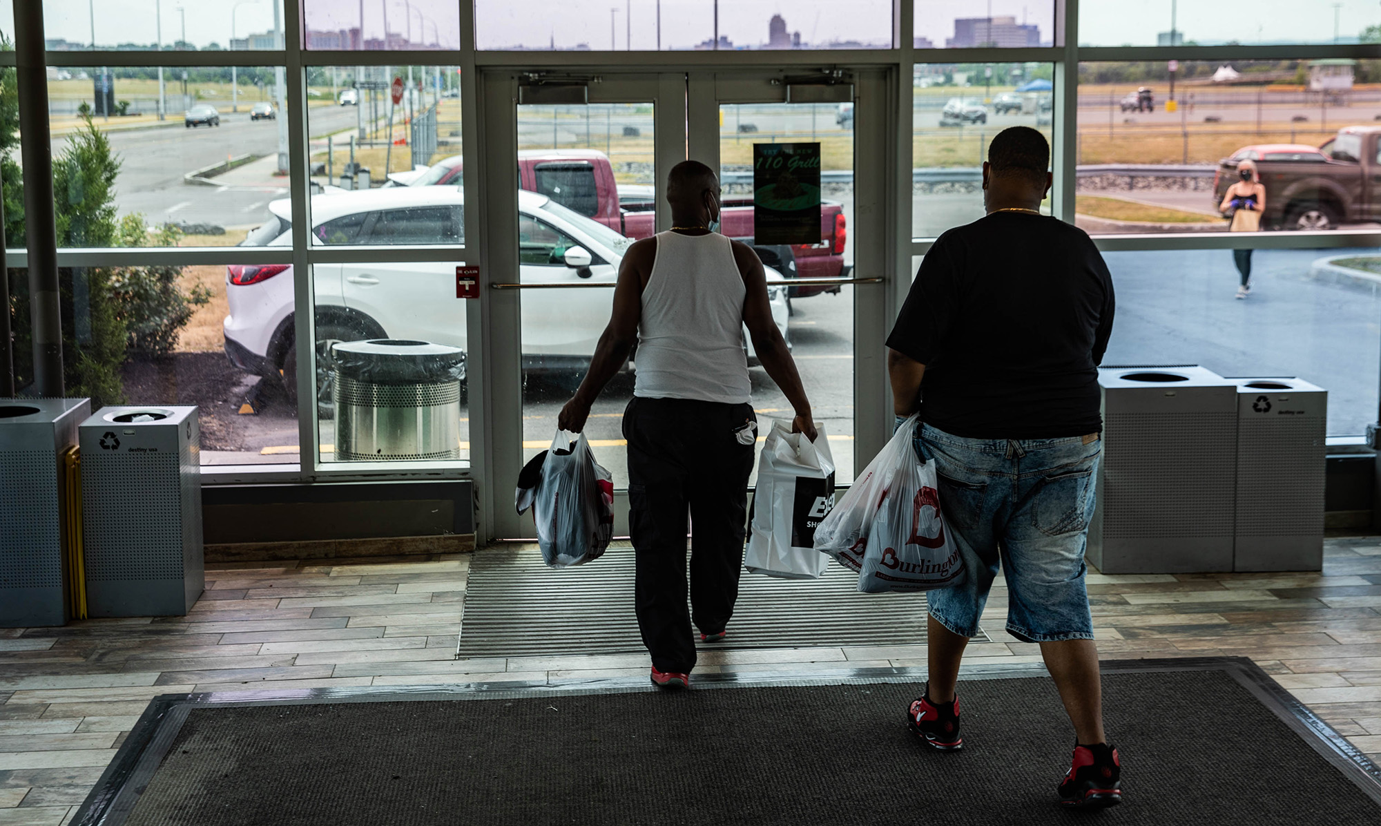 Customers carrying shopping bags exit from a mall in Syracuse, New York on July 10.