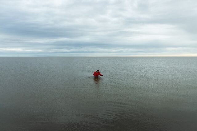 Julia Guimond pulls a stake, used to gather water samples, from inside the Beaufort Sea lagoon.