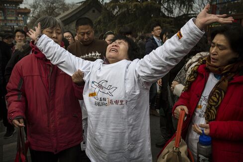 A Chinese relative of a missing passenger on Malaysia Airlines flight MH370 reacts outside the main gate of the Lama Temple in Beijing, China.