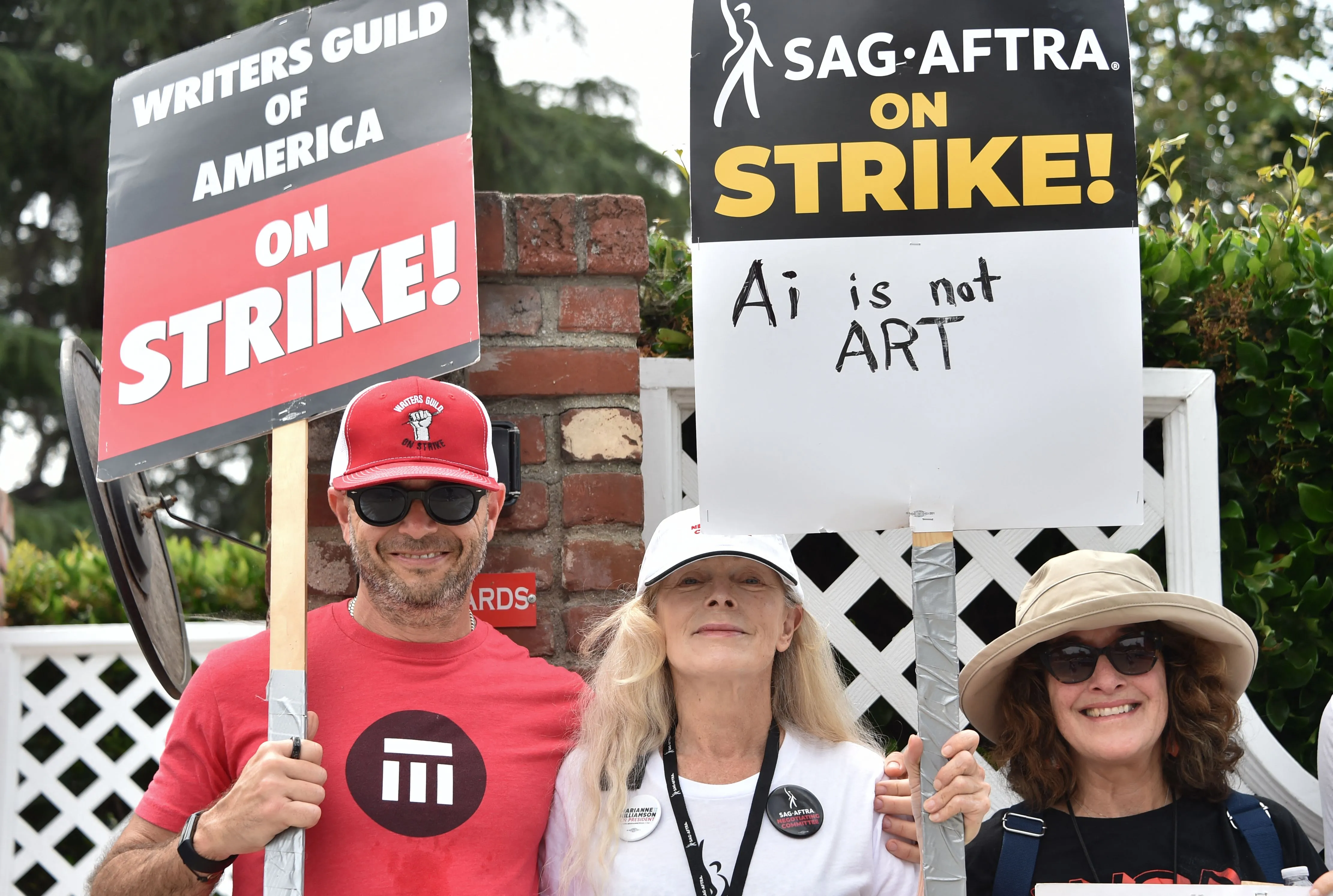 Damon Lindelof (left) and Frances Fisher (center) walk the picket line with WGA and SAG members.
