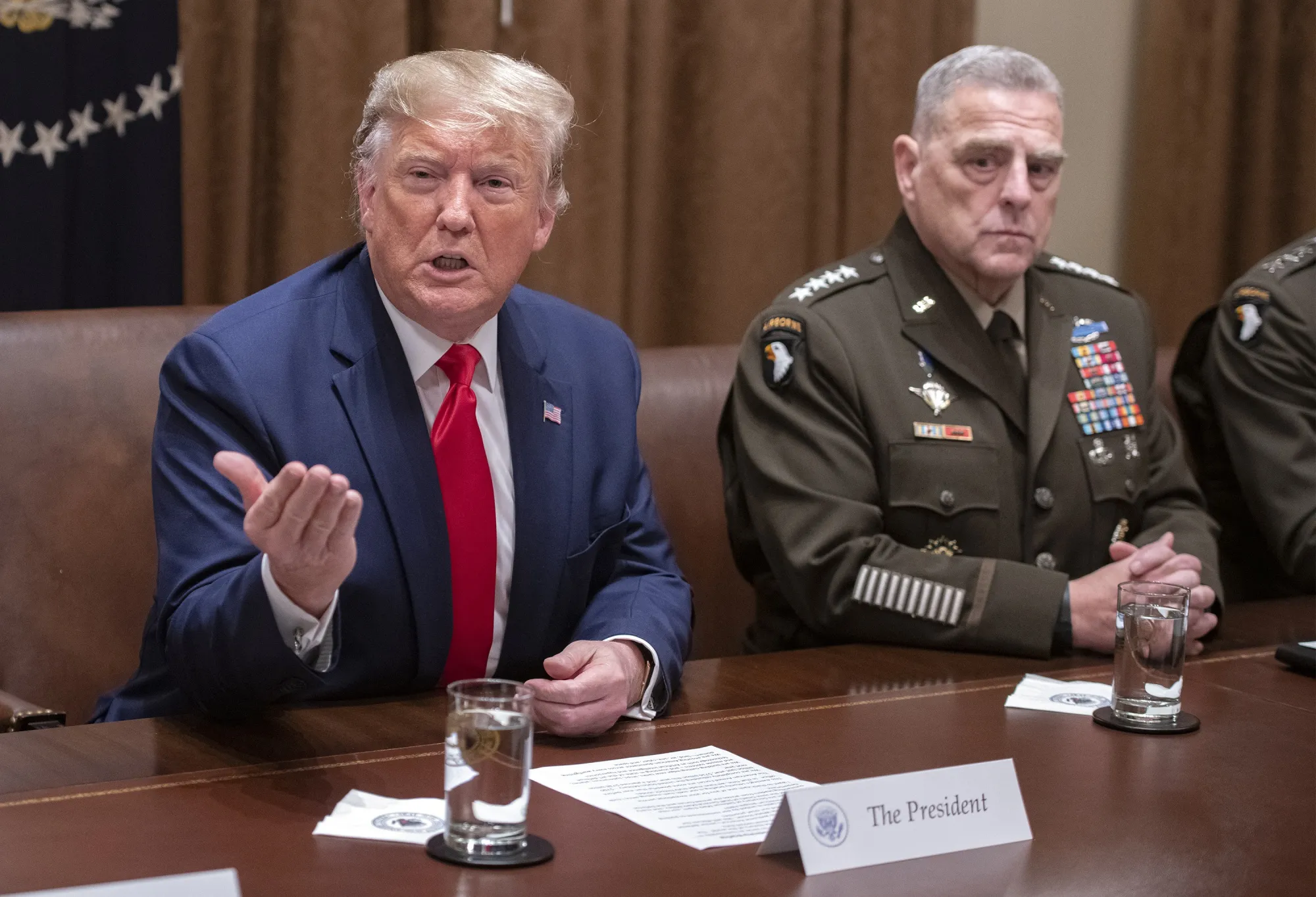 Donald Trump speaks as Mark Milley, right, listens during a briefing in Washington, in 2019. 