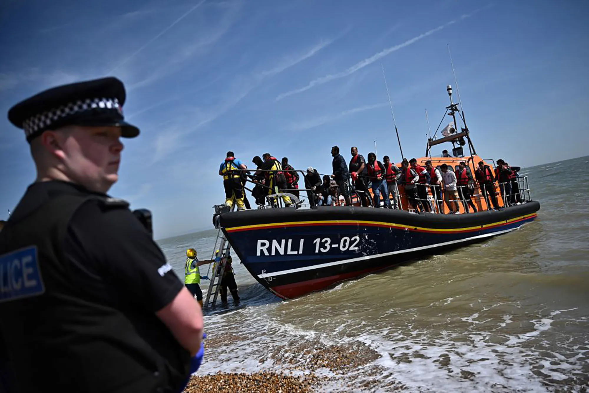 Staff help migrants disembark a&nbsp;lifeboat after they were picked up at sea while attempting to cross the English Channel.