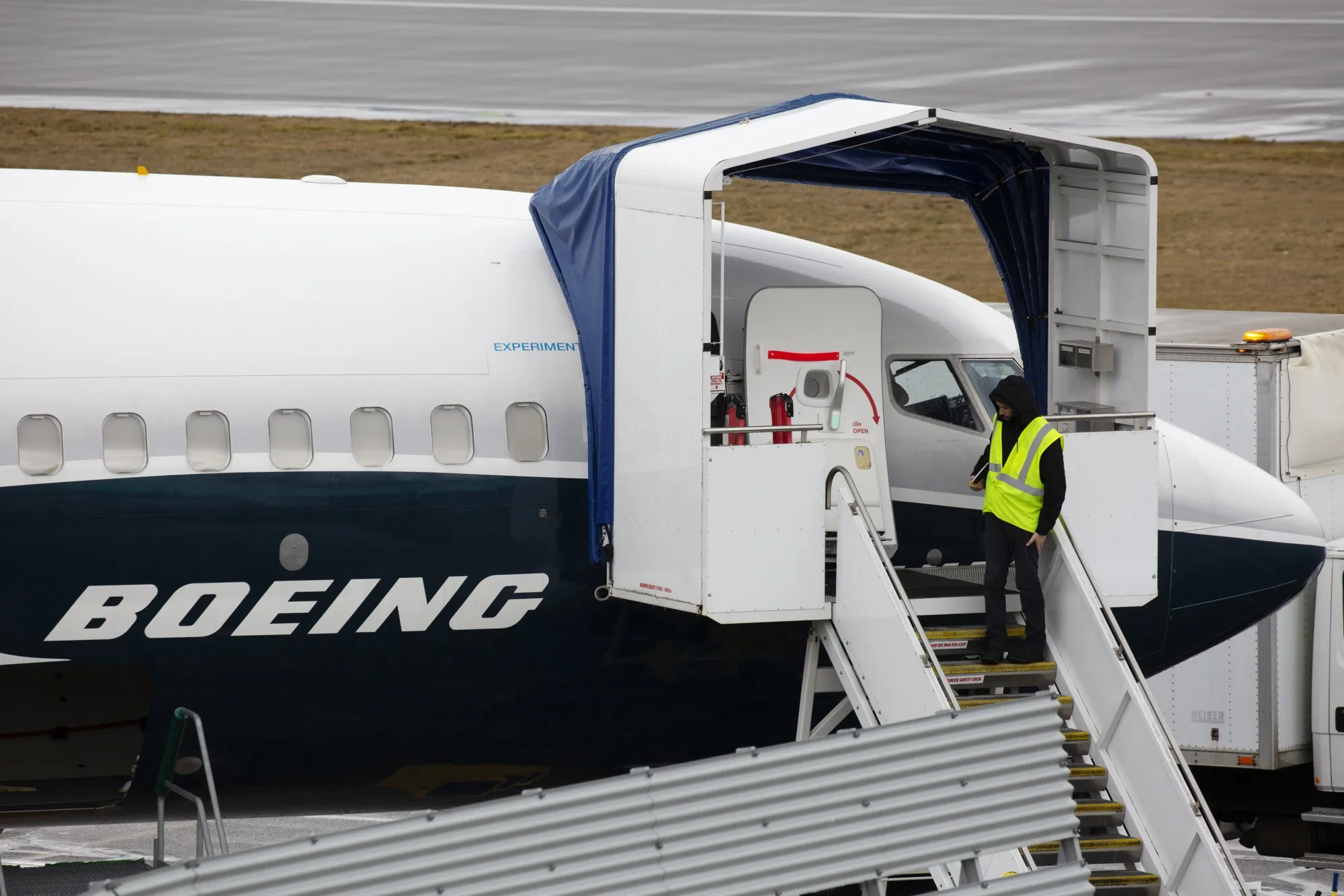 An employee stands next to a Boeing 737 Max 9 plane at the company's manufacturing facility in Renton, Washington.