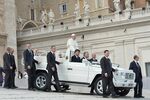 Pope Francis stands on a jeep surrounded by bodyguards during his general audience at St Peter's Square on Oct. 23
