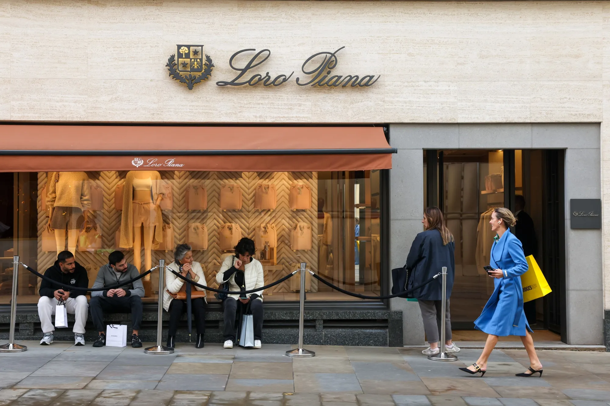 Shoppers queue to enter a Loro Piana store in central London.