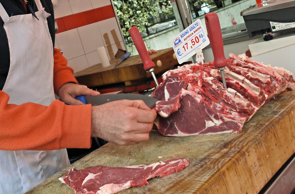 A butcher slices beef at a market in Rome, Italy, where meat will be a tough habit to break.