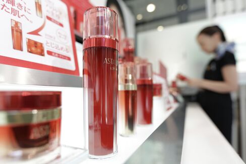 Skincare products of Fujifilm Corp.'s Astalift brand sit on display while a showroom attendant arranges the products at the company's showroom in Tokyo. Photographer: Kiyoshi Ota/Bloomberg