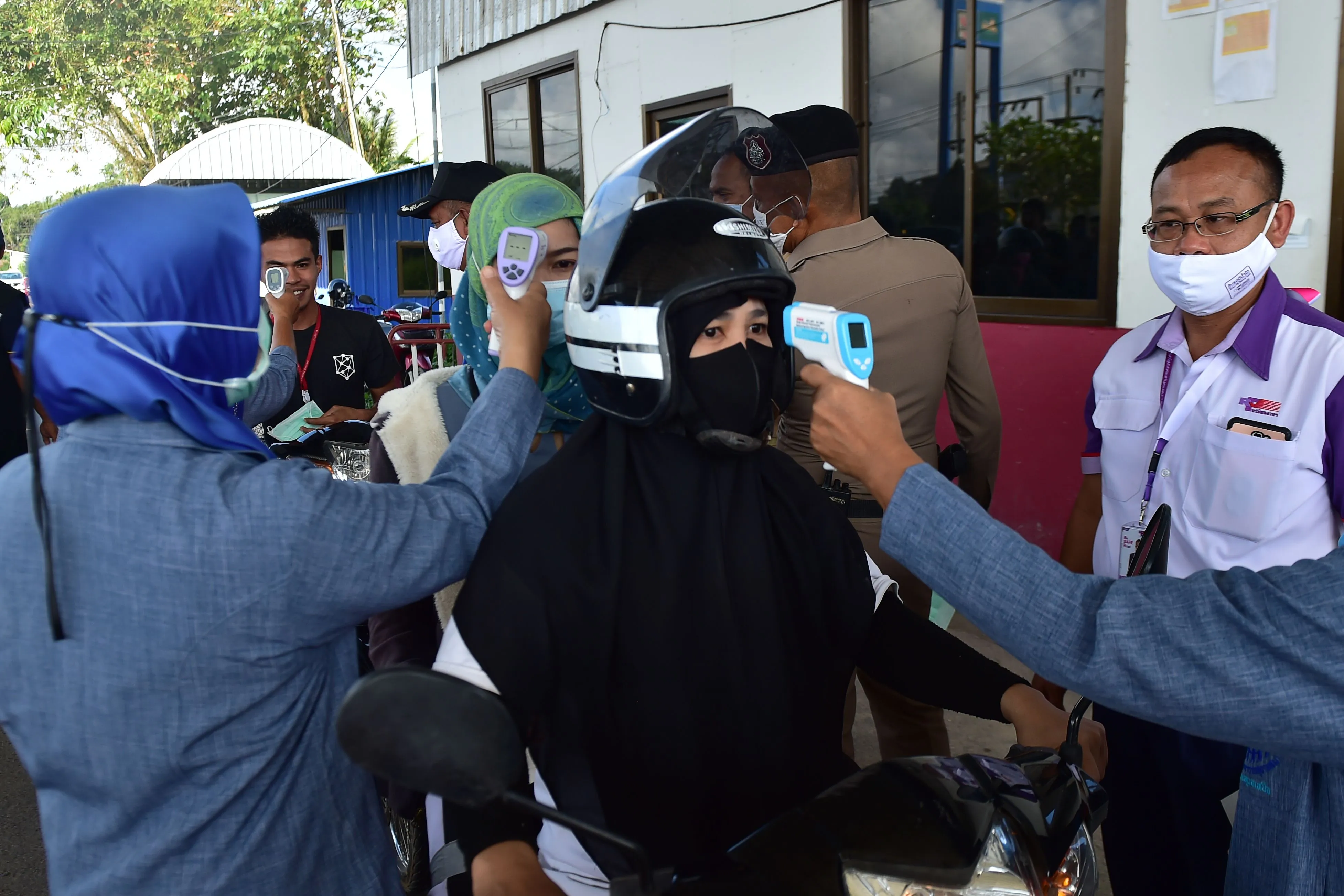 People have their temperature taken at a checkpoint&nbsp;in the southern Thai province of Narathiwat on Dec. 29.