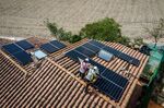 Engineers&nbsp;install solar panels onto the roof of a residential property in Barcelona, Spain.