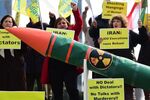 Iranian opposition supporters stage a demonstration displaying a fake nuclear missile, ahead of ongoing nuclear talks between EU foreign ministers and Iran, in front of the European institutions, in Brussels, on March 16. Photographer: Emmanuel Dunand/AFP/Getty Images
