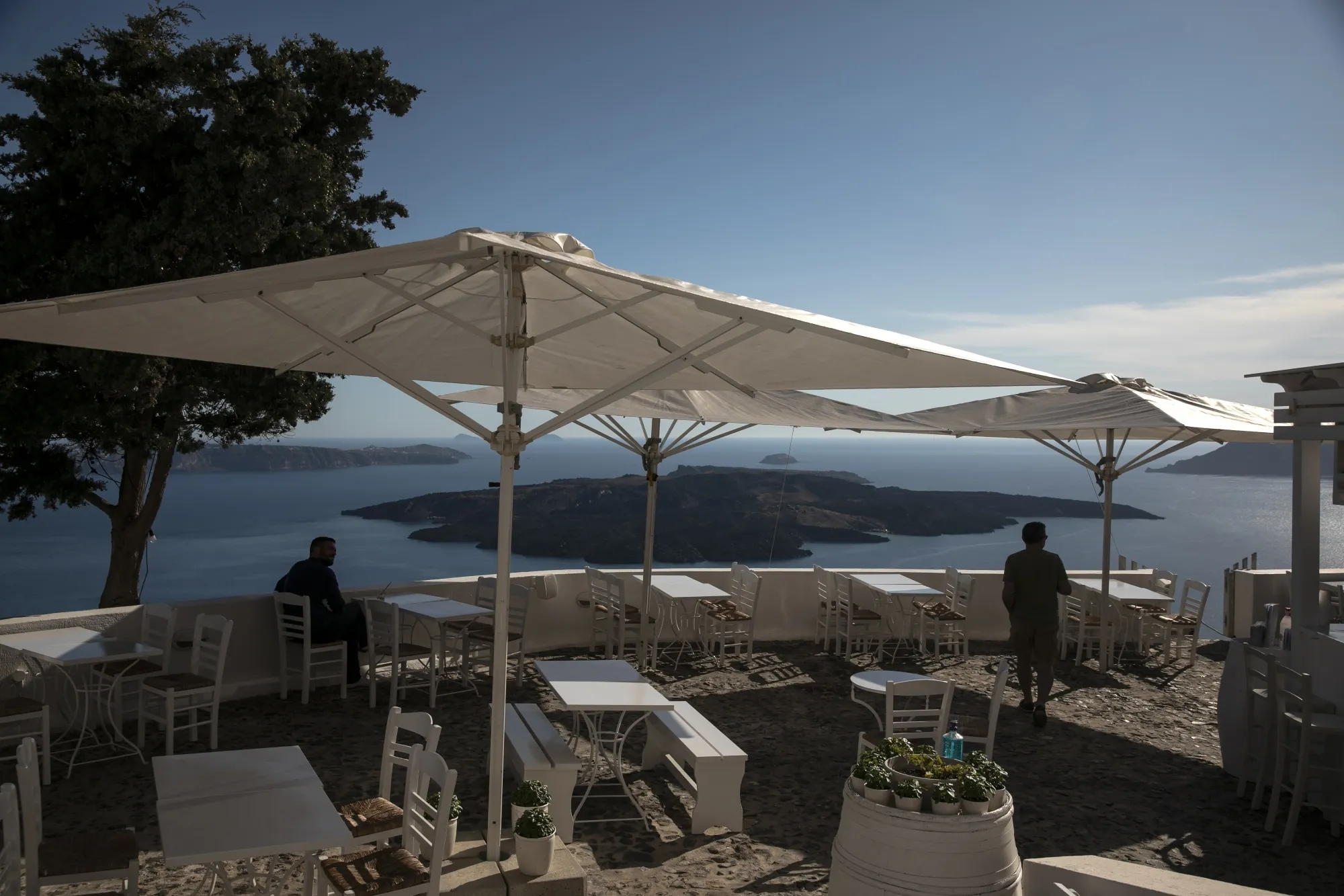 People look at the view from a restaurant terrace on the Greek island of Santorini.