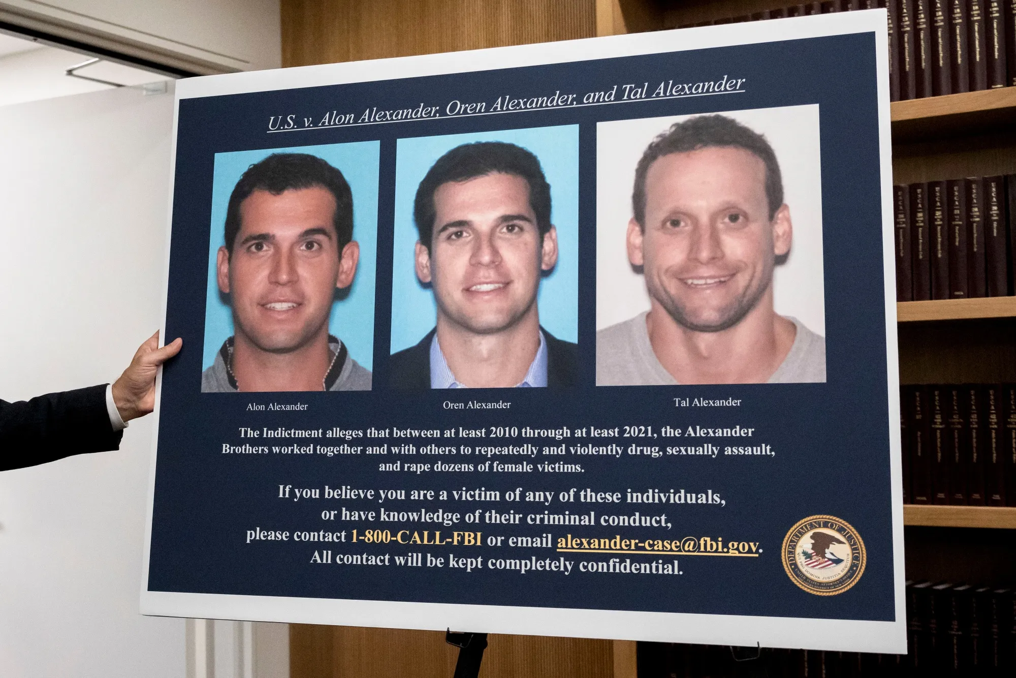 A display showing images of Alon, Oren, and Tal Alexander prior to a news conference in New York in 2024.