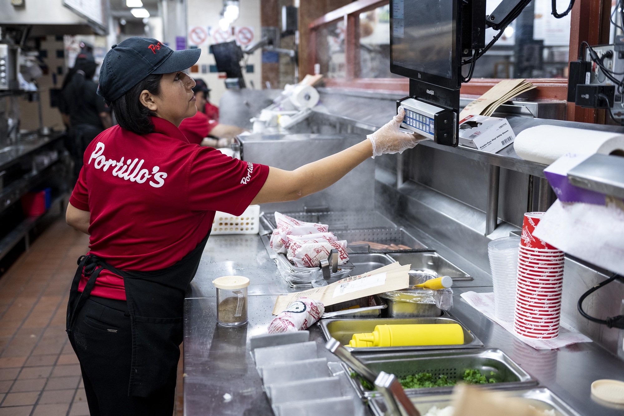 An employee checks on orders to prepare at a Portillo's restaurant in Chicago, Illinois, US, on Tuesday, Sept. 27, 2022.