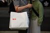 A customer carrying a branded shopping bag exits a Uniqlo store, operated by Fast Retailing Co., in Tokyo, Japan, on Saturday, April 6, 2019.