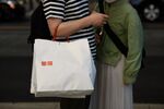 A customer carrying a branded shopping bag exits a Uniqlo store, operated by Fast Retailing Co., in Tokyo, Japan, on Saturday, April 6, 2019.