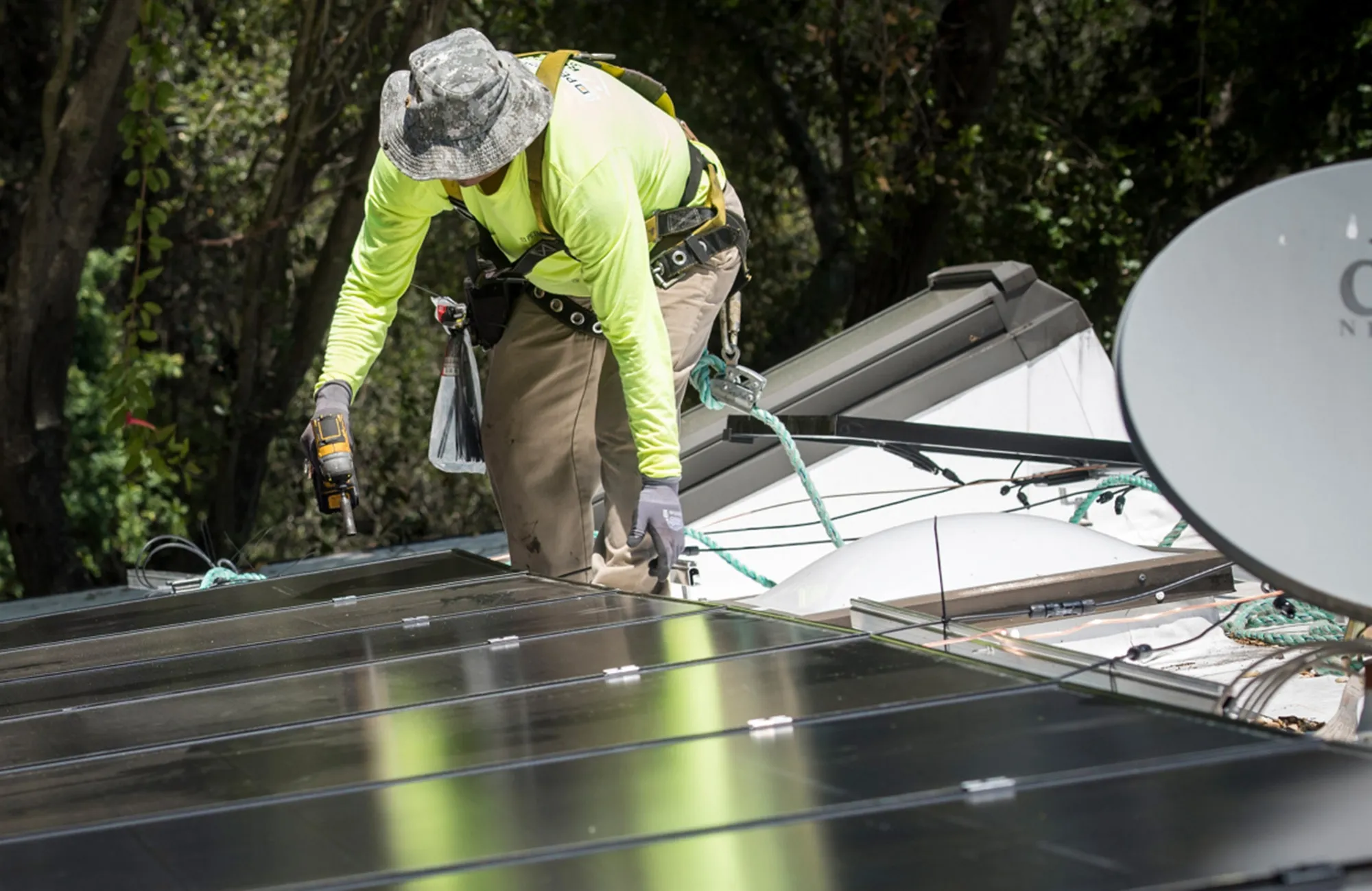 A worker installs solar panels on the roof of a home in California.