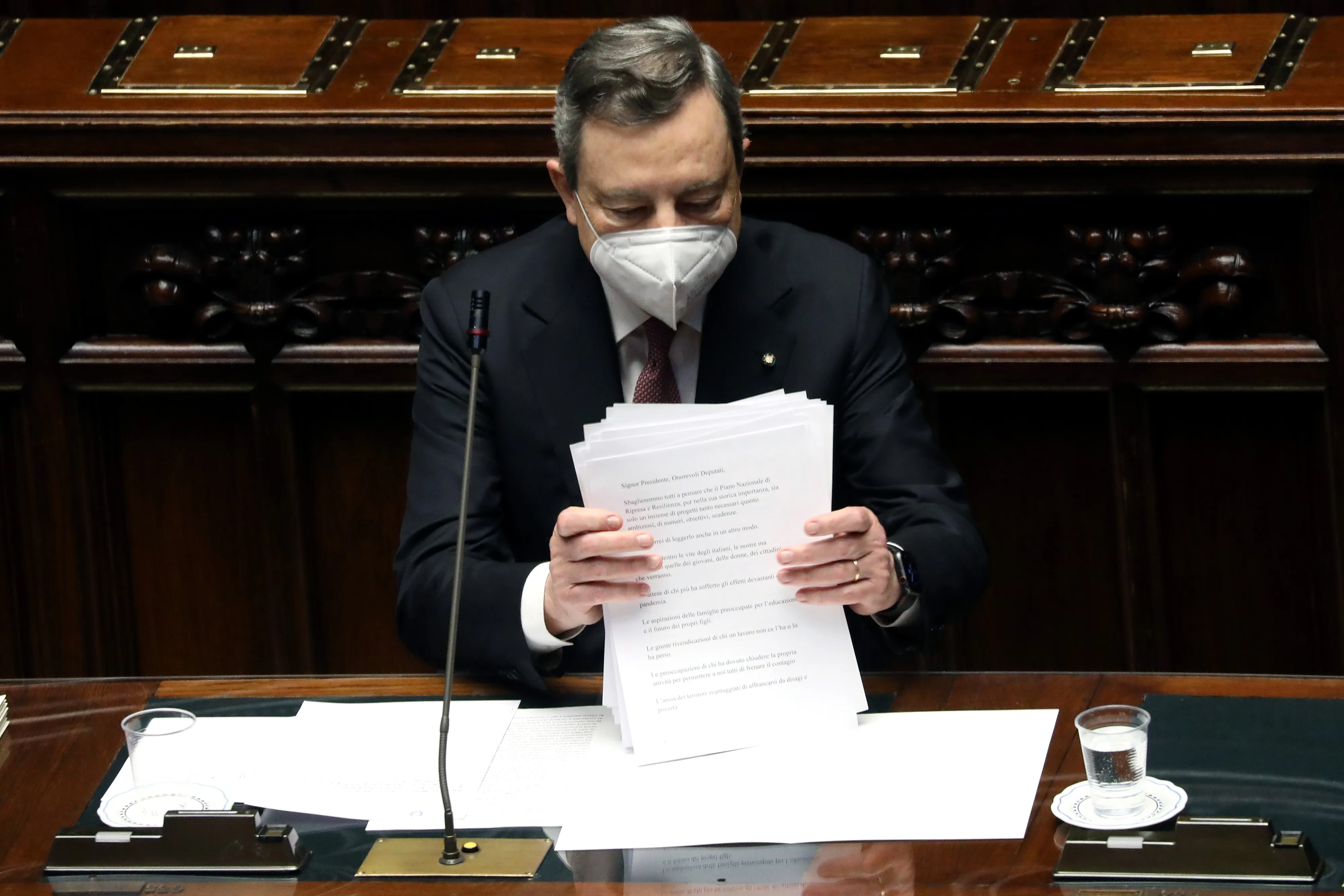 Mario Draghi collects his papers after presenting his economic recovery plan in the lower house of Parliament in Rome on April 26.