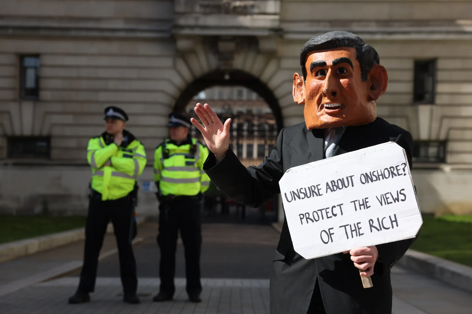 A climate protester takes on the chancellor’s image in London on April 11.