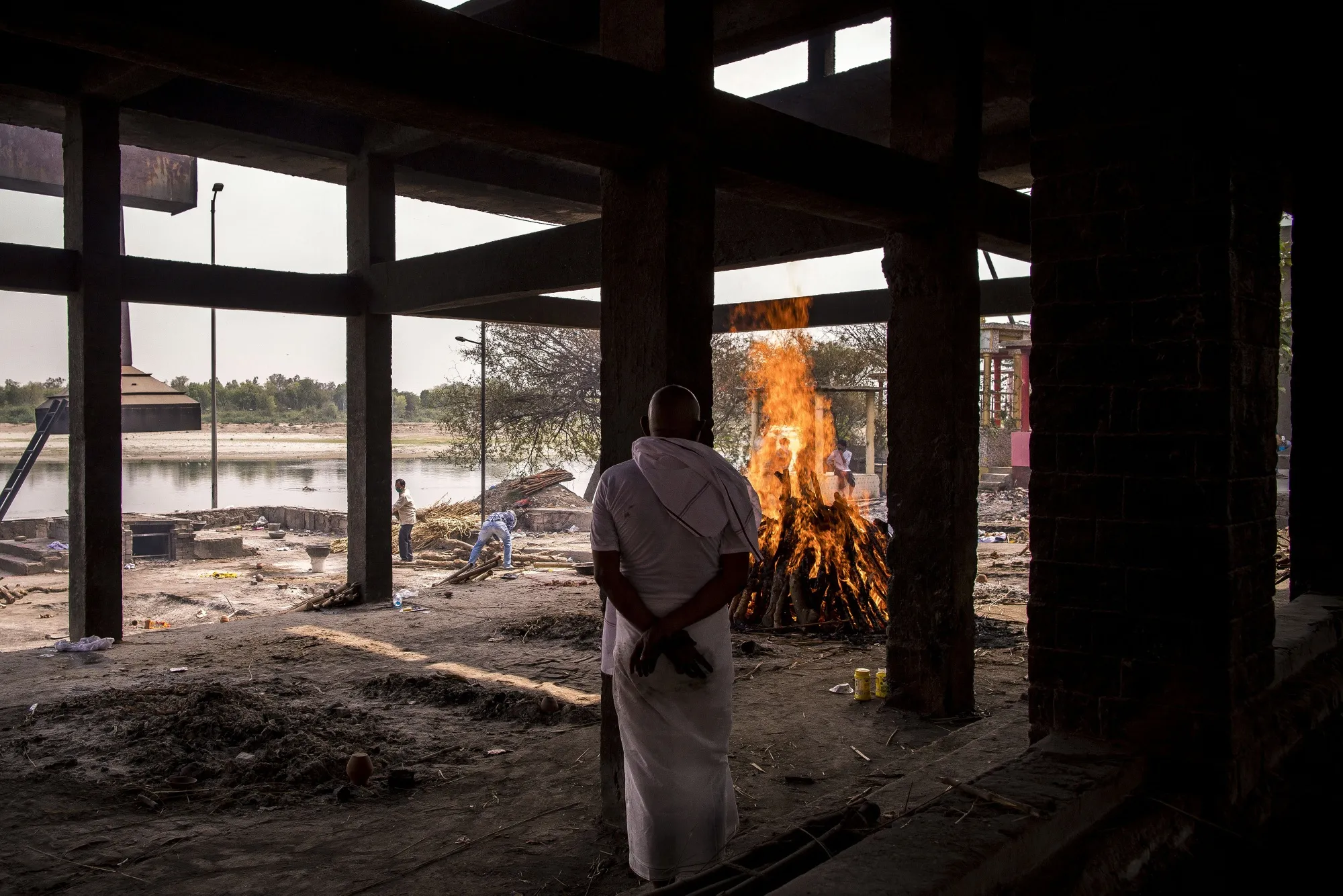 A relative observes the burning pyre of a Covid-19 fatality at a crematorium in Agra, on May 3.