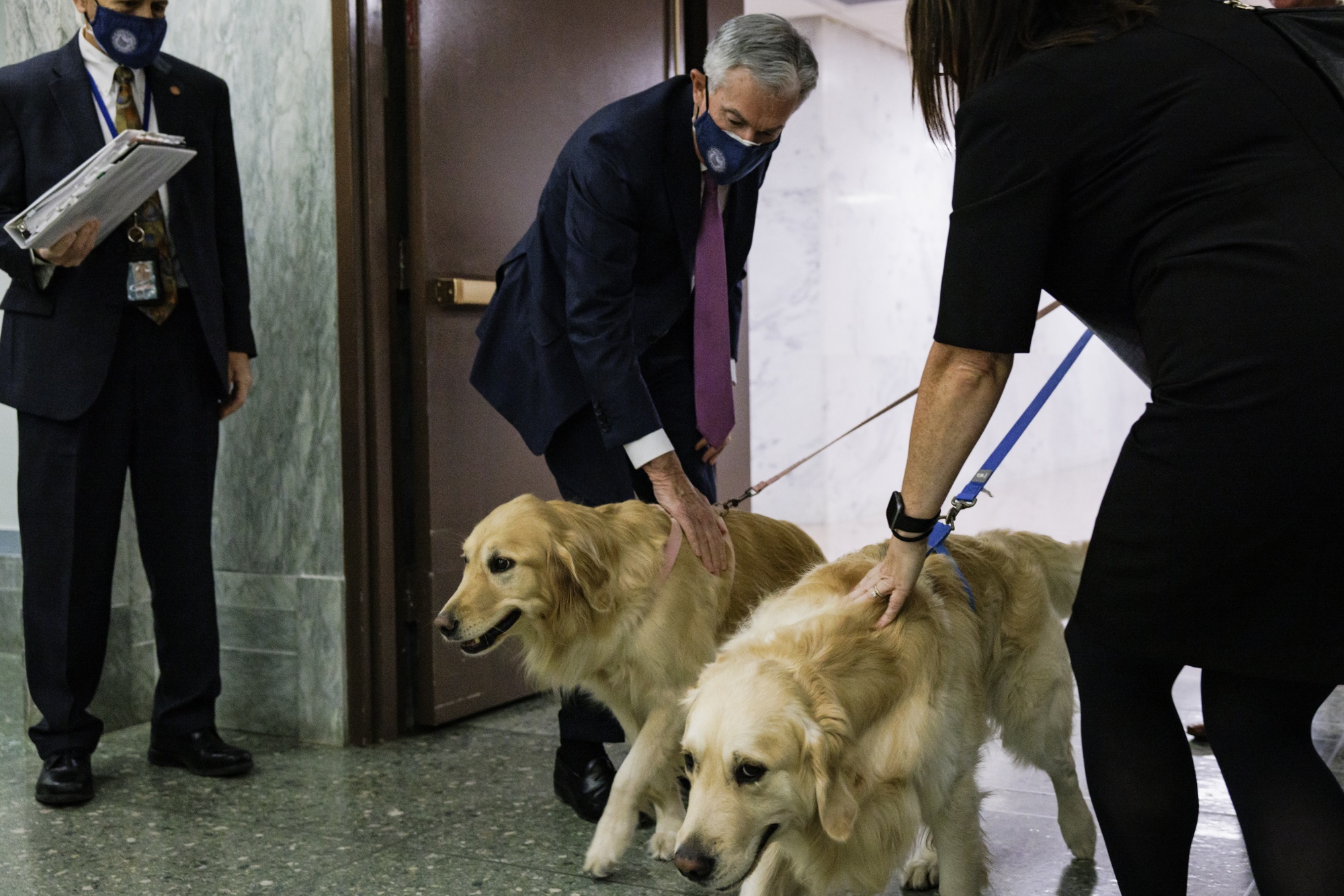  Jerome Powell pets a golden retriever dog