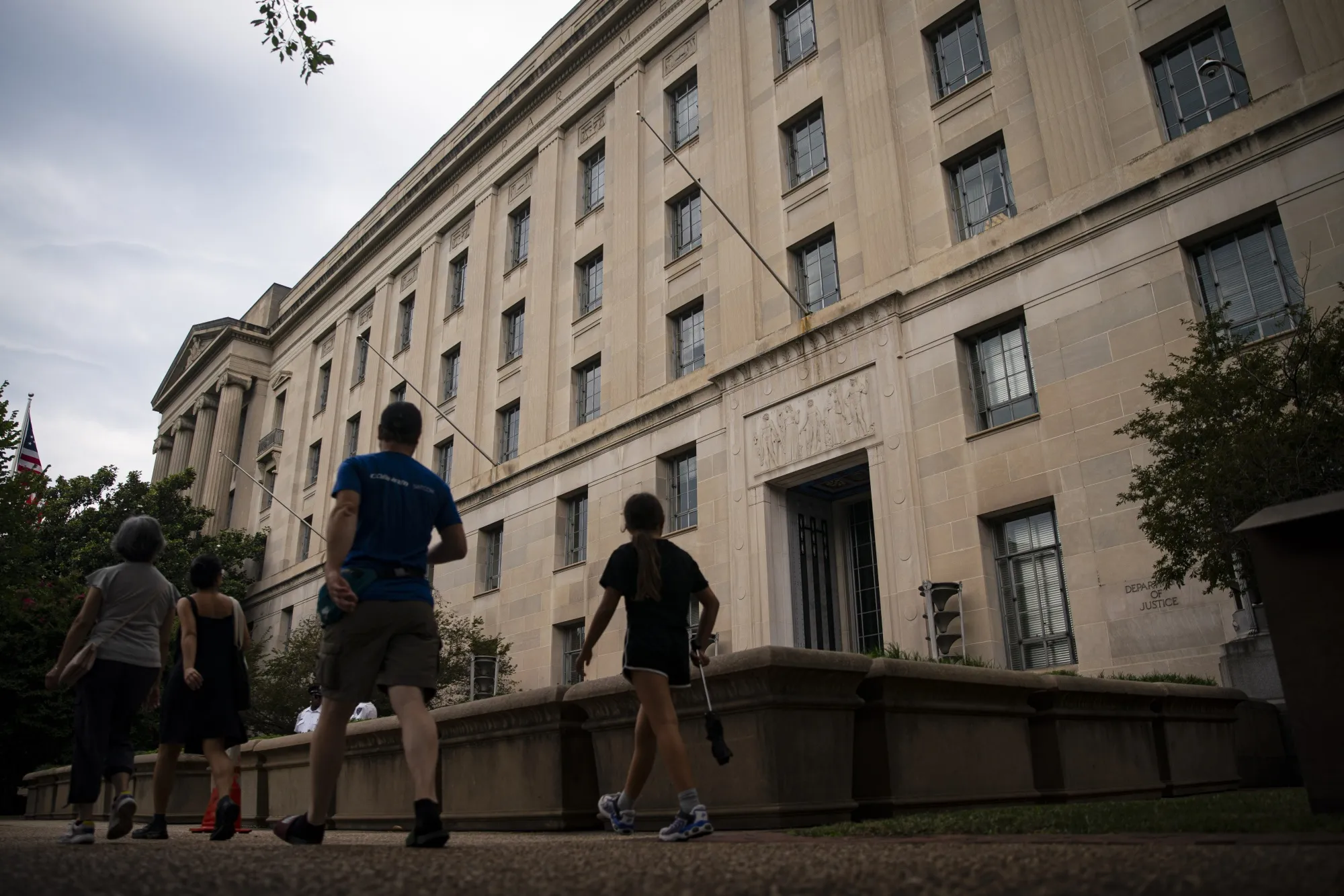 Pedestrians walk past the US Department of Justice headquarters in Washington, DC.