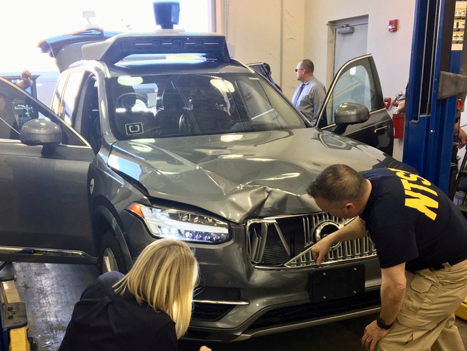  U.S. National Transportation Safety Board (NTSB) investigators examine the self-driving Uber vehicle involved in a fatal accident in Tempe, Arizona, in March.