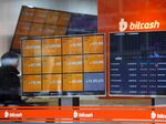 A man walks past a screen showing exchange rates of cryptocurrencies at an exchange in Seoul on December 20, 2017.