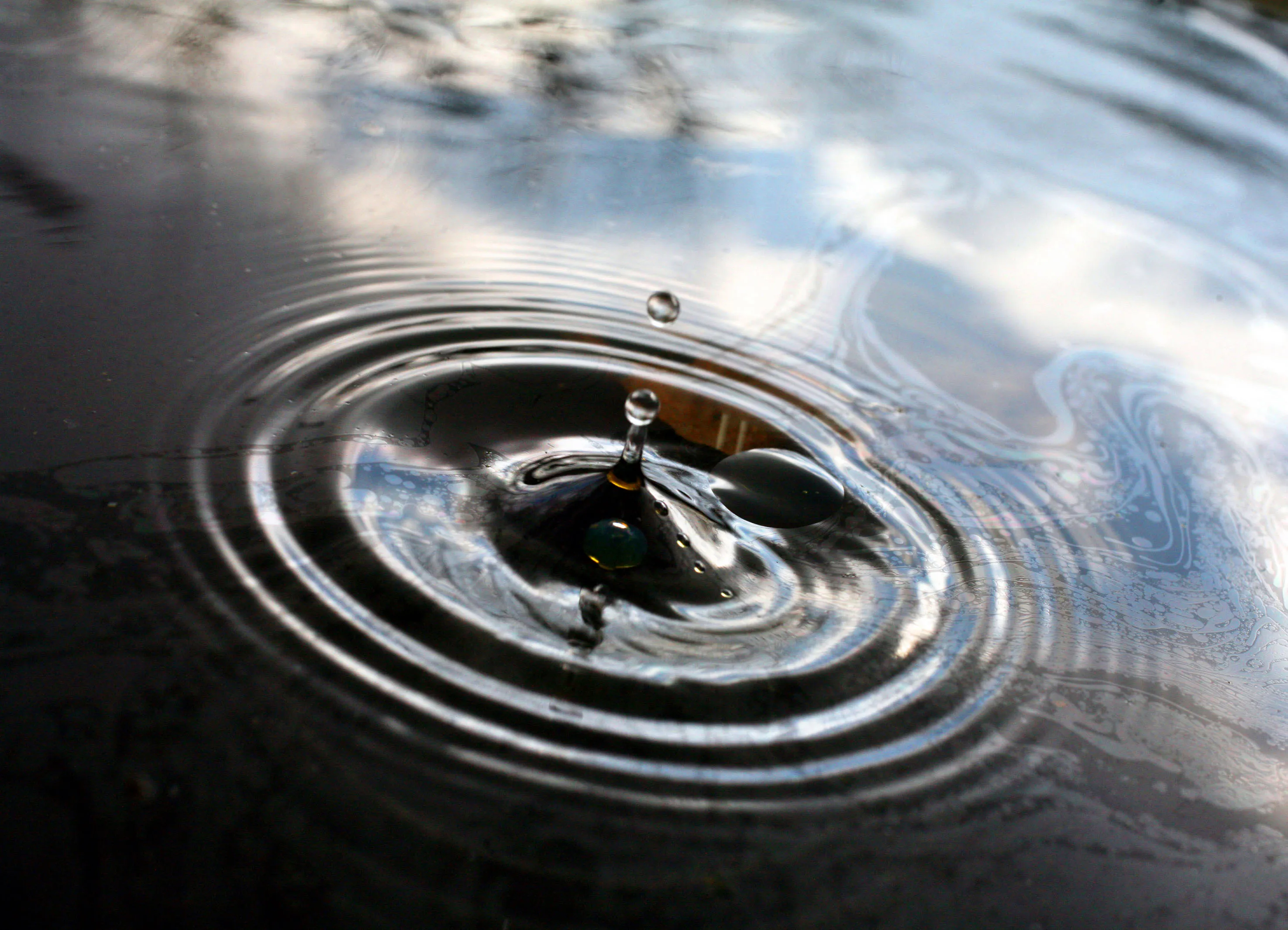 Water droplets fall into a pool of oil in Littlebury, U.K., on Thursday, March 27, 2008.