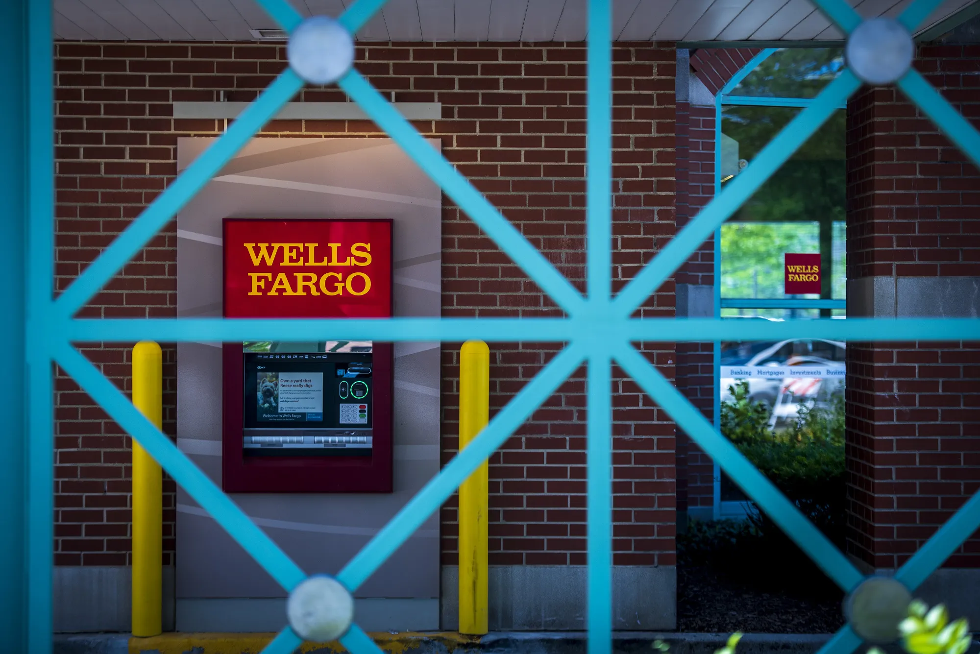 An automatic teller machine is seen behind a fence at a Wells Fargo &amp; Co. bank branch in Schaumburg, Illinois.