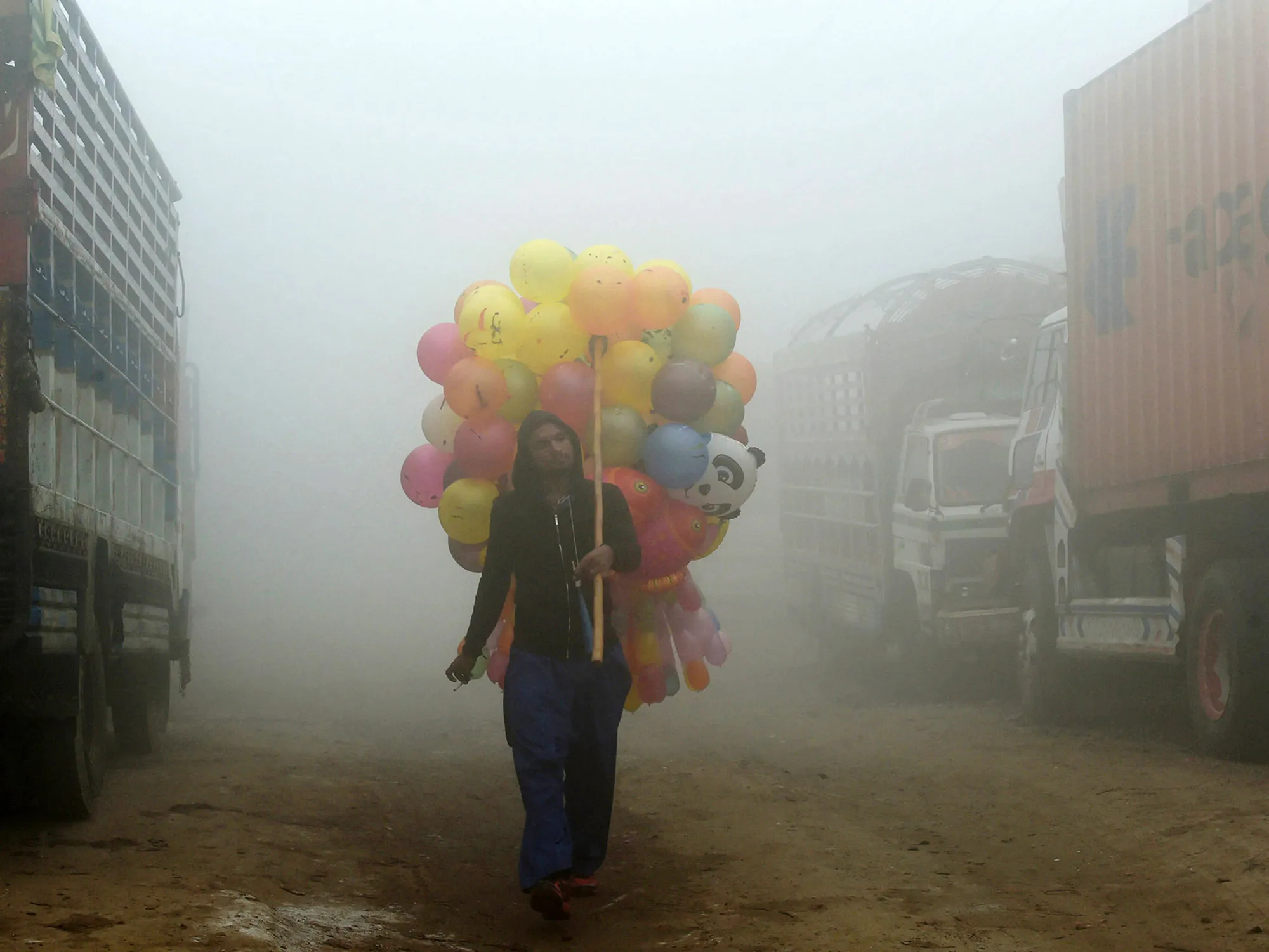 A Pakistani vendor carries balloons on a street amid heavy smog in Lahore. The fast-developing country has suffered&nbsp;from some of the world’s worst air pollution.