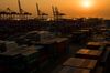 Containers sit stacked beneath gantry cranes at the Sun Kwang Newport Container Terminal (SNCT) at sunset in Incheon New Port in Incheon, South Korea.