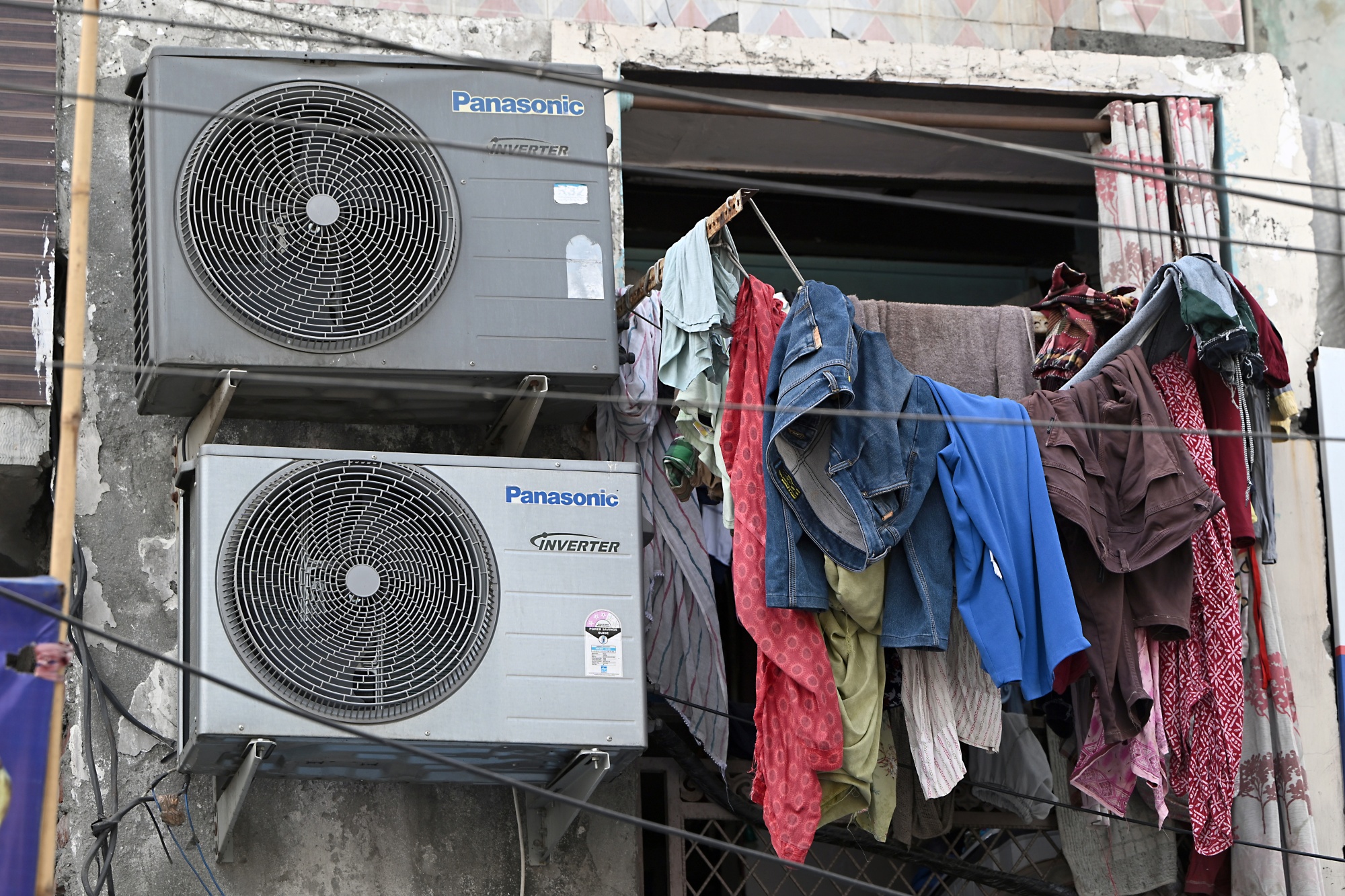 Air conditioning units hang from a building in New Delhi.