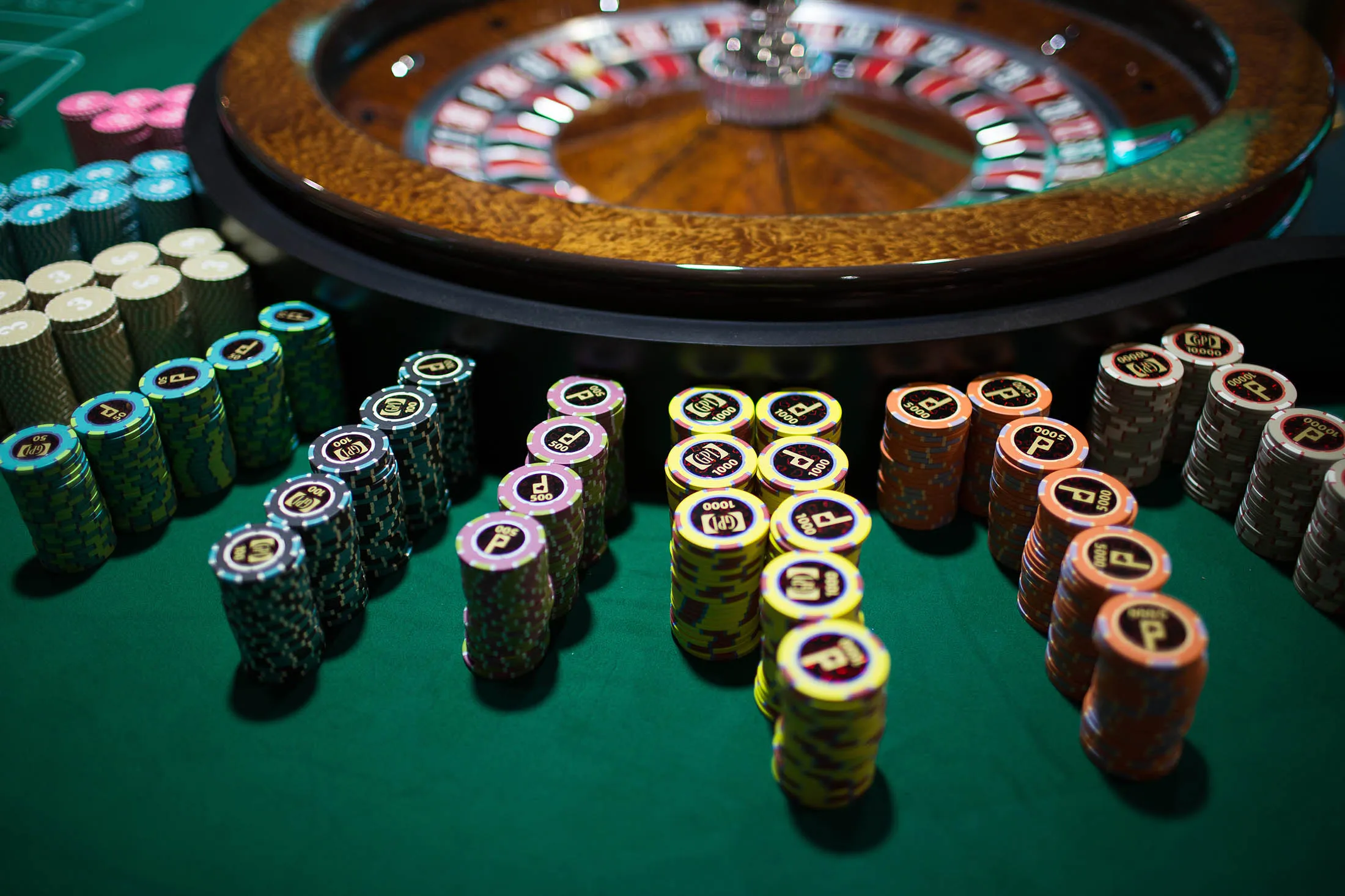 Stacks of gaming chips stand next to a roulette wheel during the All Asia Dealers' Championship at the Global Gaming Expo (G2E) inside the Venetian Macau resort and casino, operated by Sands China Ltd., a unit of Las Vegas Sands Corp., in Macau, China, on Tuesday, May 19, 2015. The gaming expo runs through May 21.
