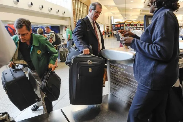 Passengers check their luggage at the Delta counter at Hartsfield-Jackson Atlanta International Airport on Sept. 27, 2013
