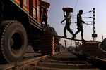 Workers load sacks of cement onto trucks parked at a rail yard on the outskirts of Patna, Bihar, India.