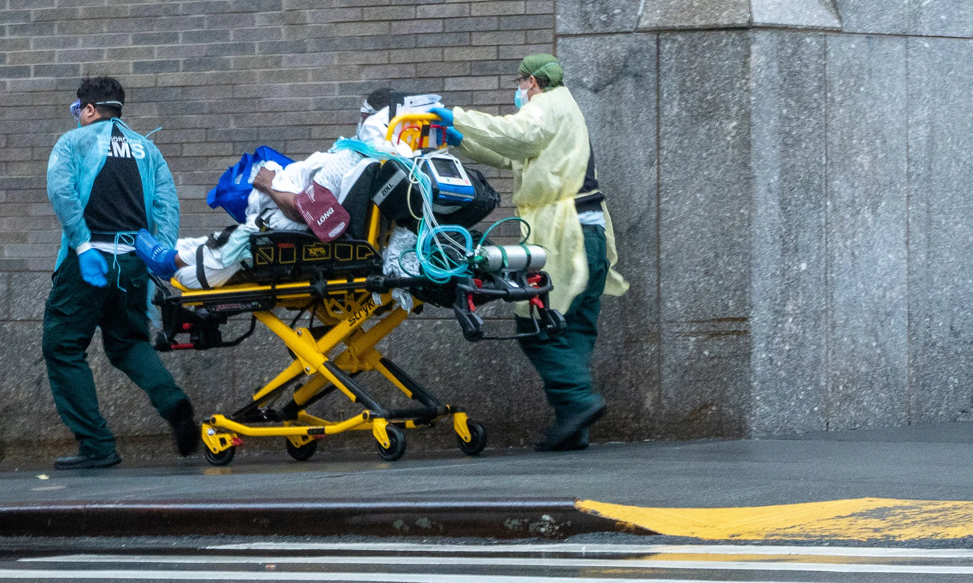 EMS workers transport a patient outside a hospital&nbsp;in New York.