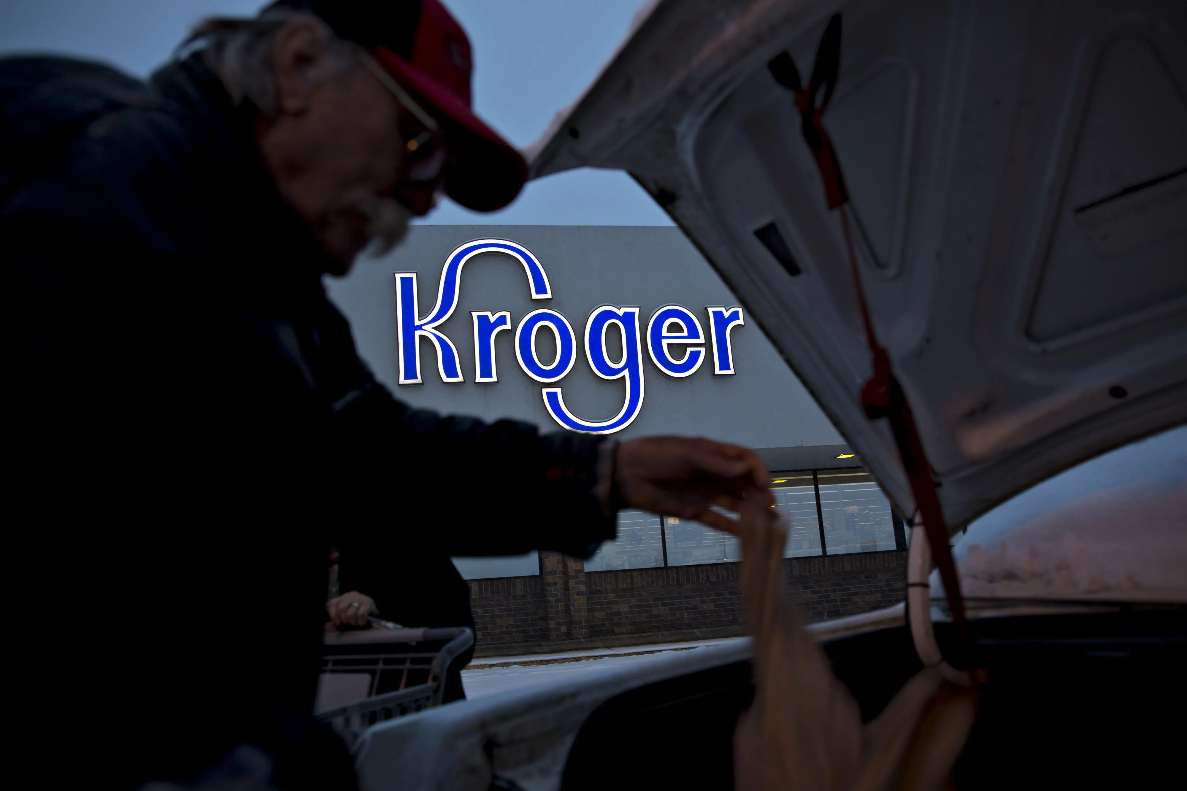 A shopper loads items into a vehicle outside of a Kroger Co. supermarket.
