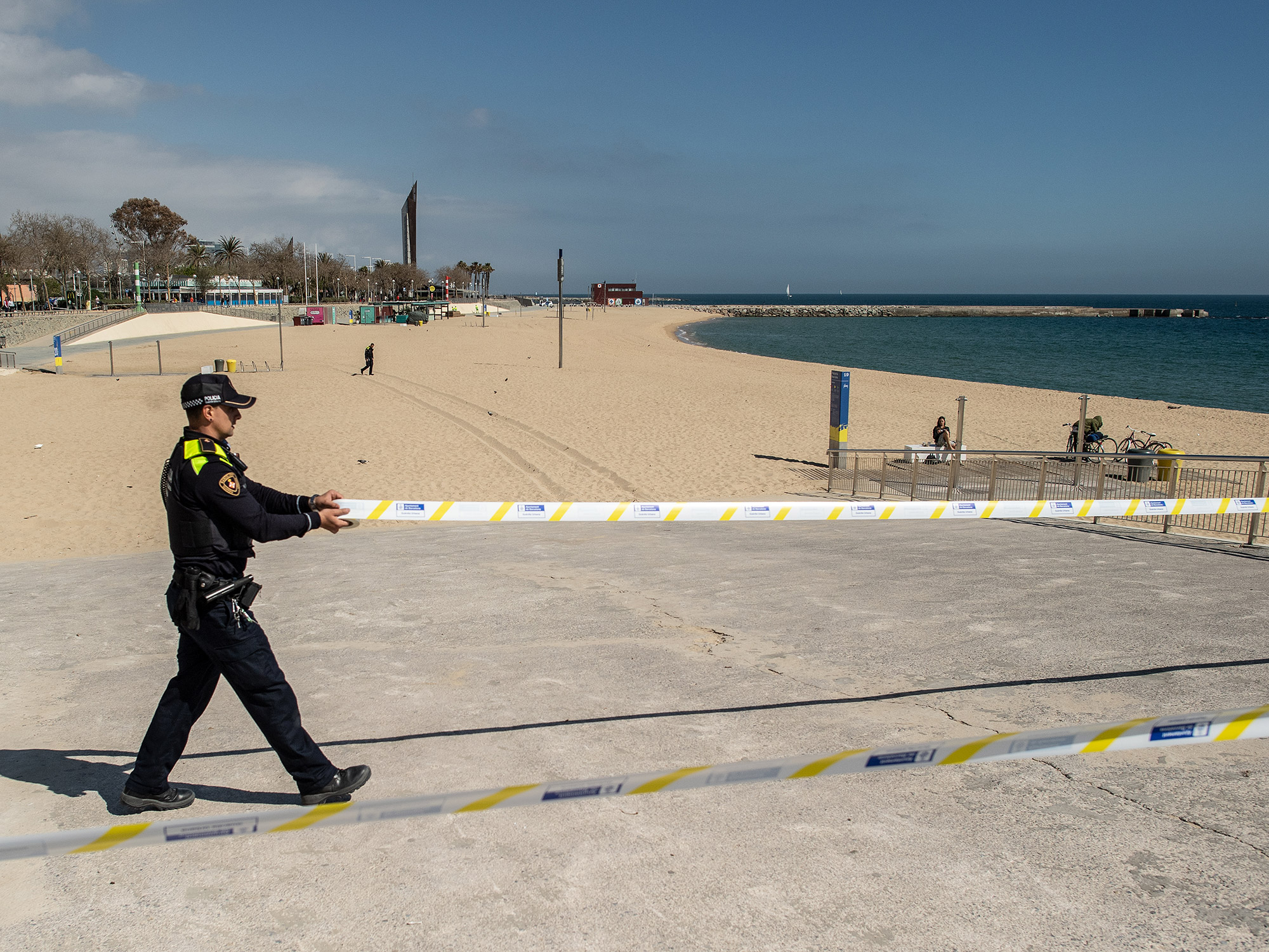 A metropolitan police officer closes access to La Mar Bella beach in Barcelona, on March 15.&nbsp;