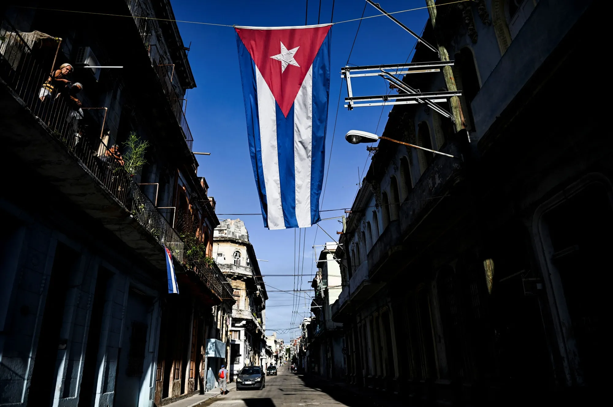 A cuban flag hangs in a street of Havana.