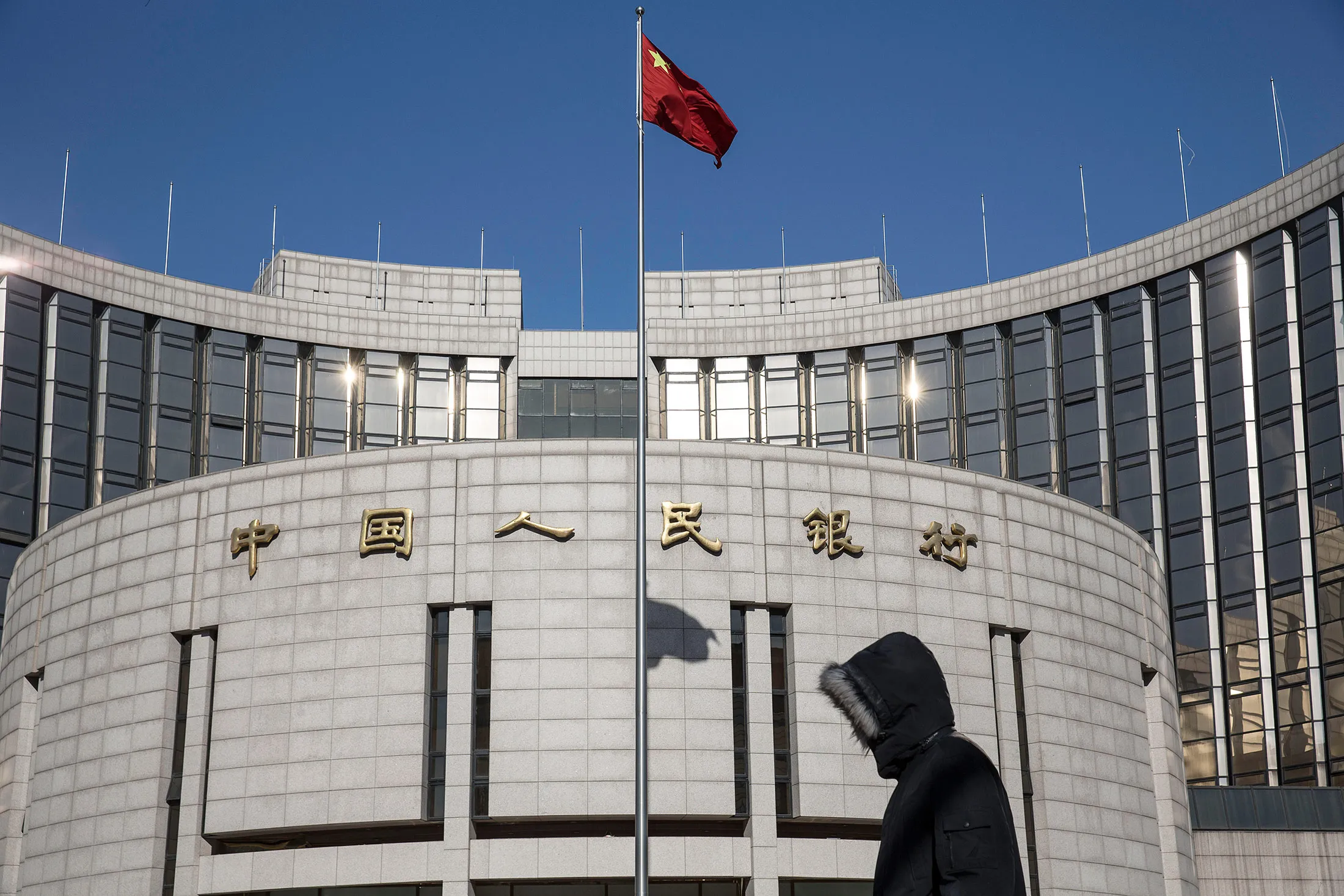 Pedestrians walk past the People's Bank of China in Beijing.
