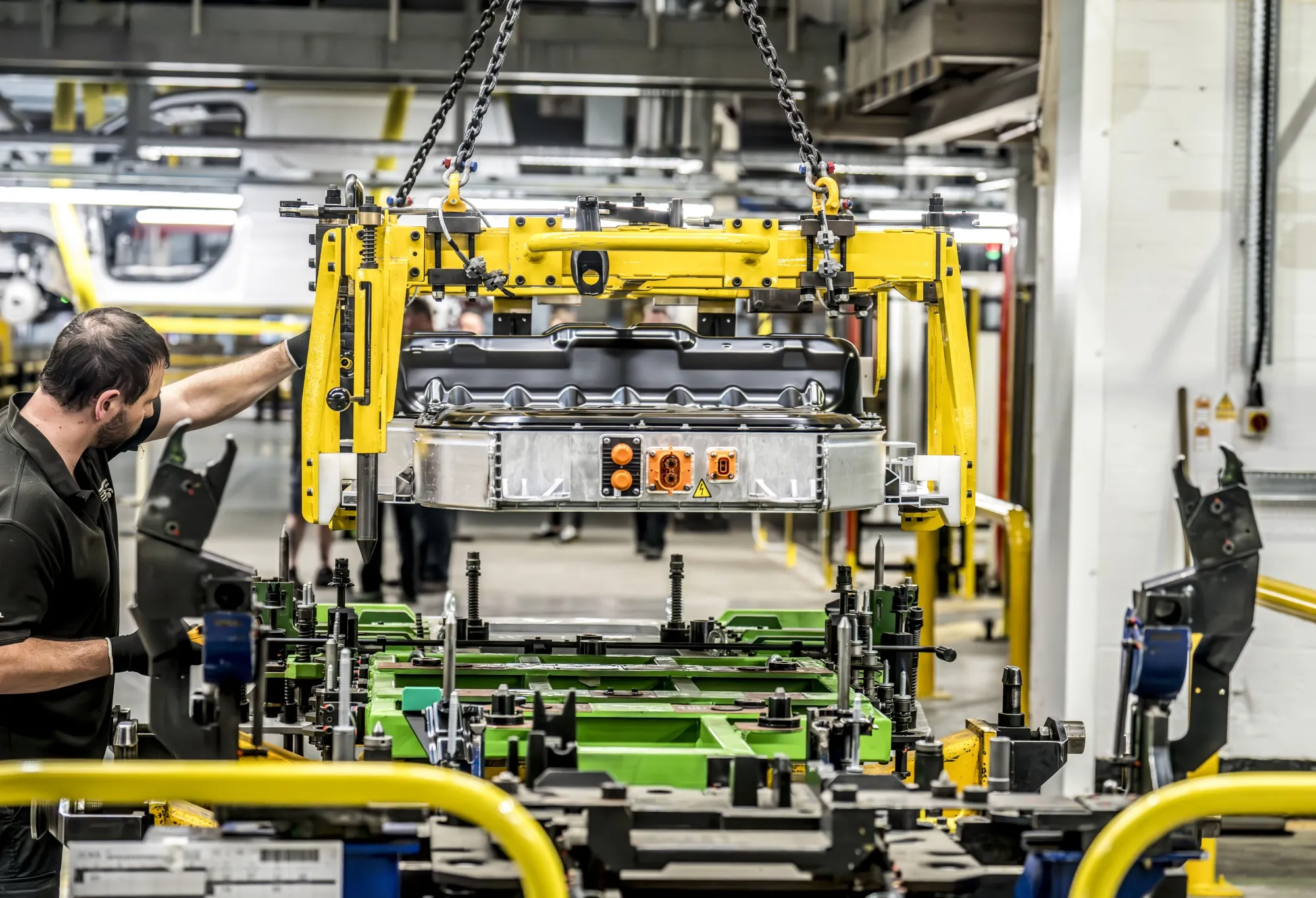 workers assemble the base of an electric vehicle body in Ellesmere Port, England.