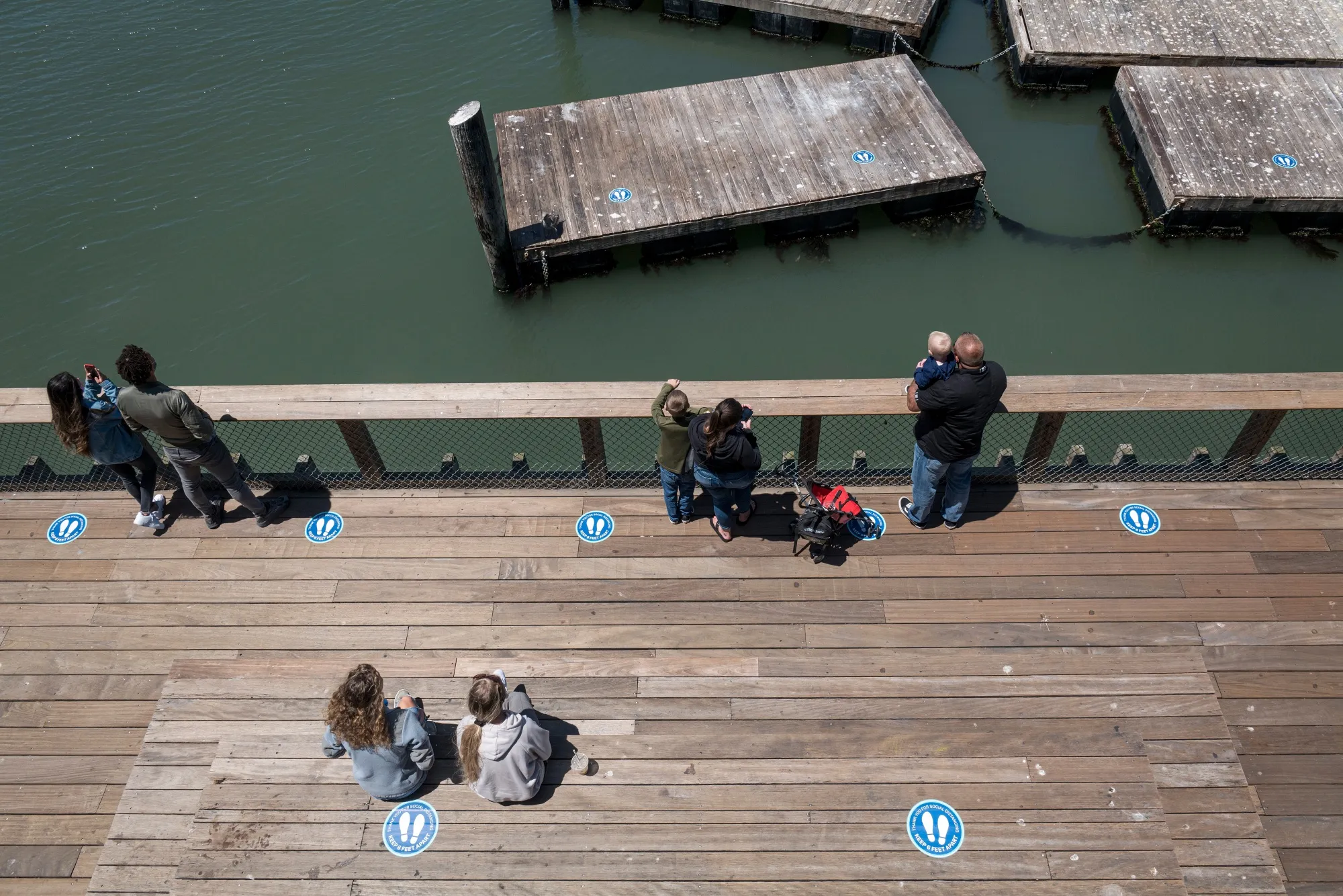 People stand on Pier 39 in San Francisco on June 22.