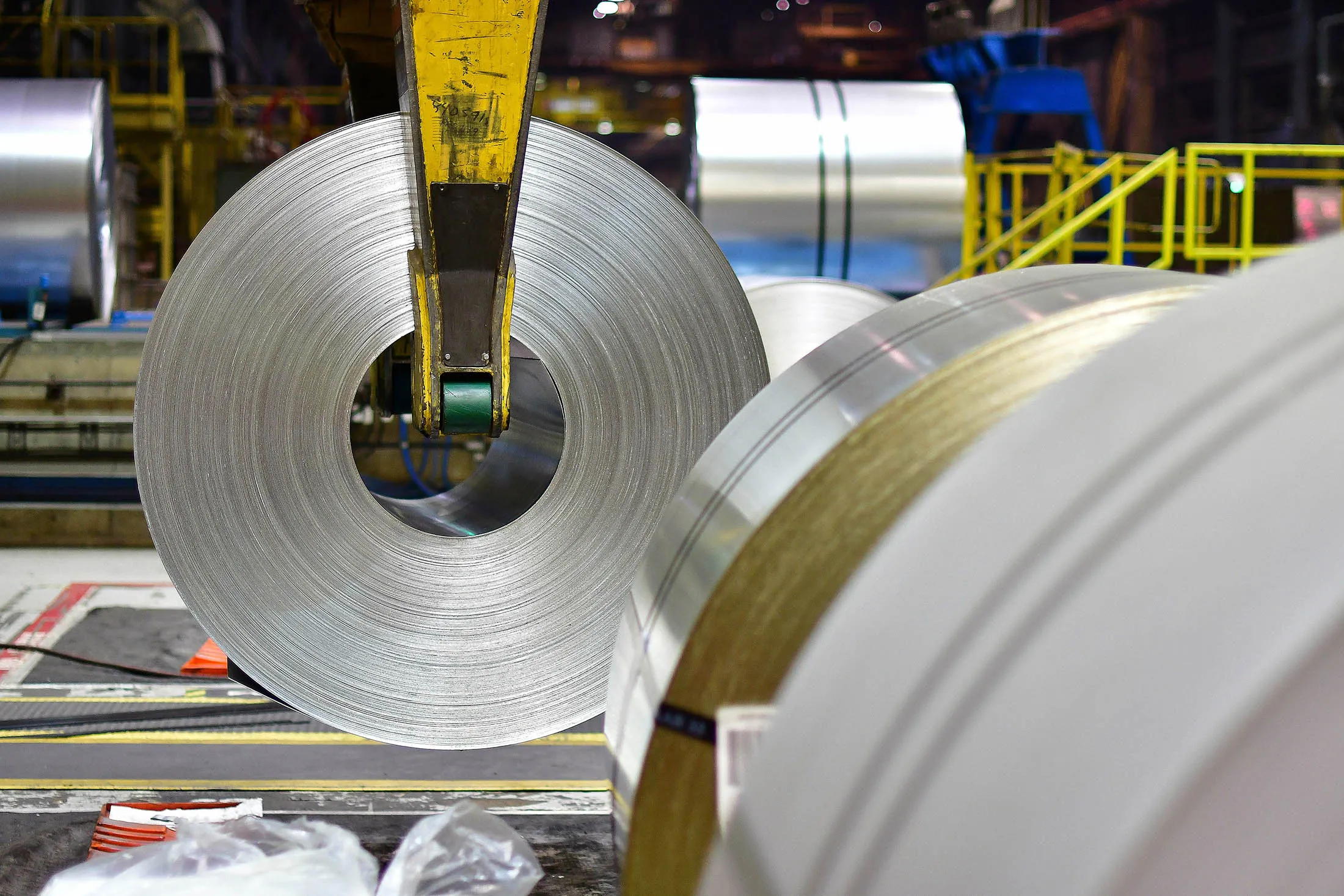 A crane places a roll of coiled steel on the floor at a steel plant in Hamilton, Ontario, Canada.