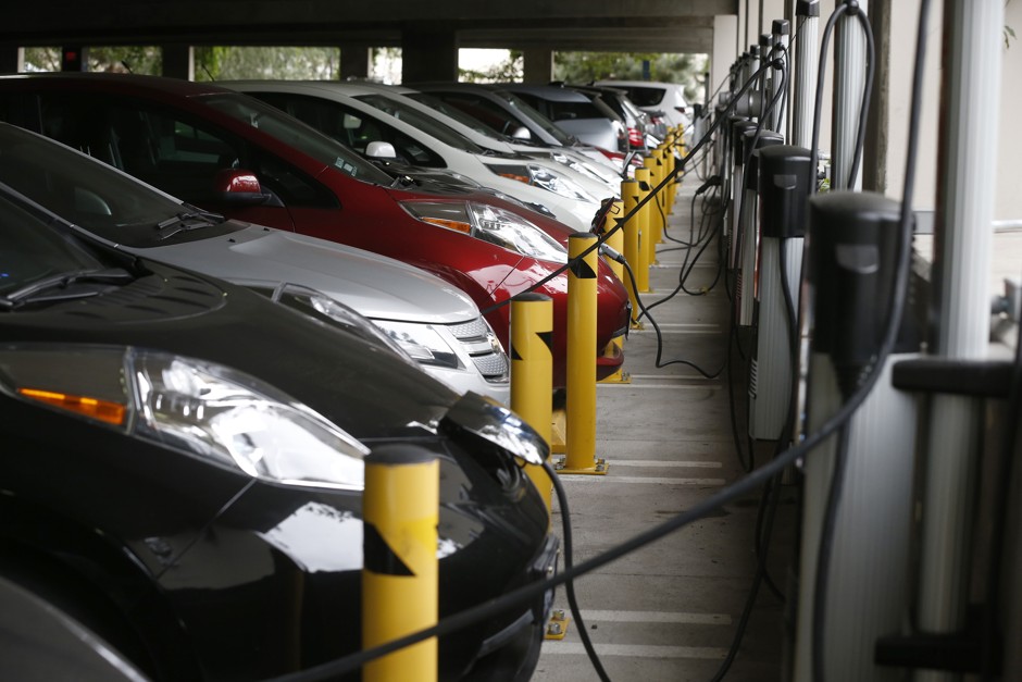 Electric cars sit charging in a parking garage at the University of California, Irvine.