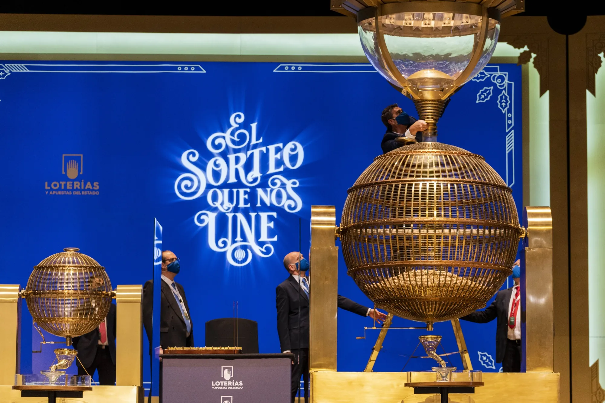 Workers prepare numbered lottery balls at Madrid's Teatro Real opera house during Spain's bumper Christmas lottery draw known as El Gordo, or The Fat One, in Madrid, Spain, Wednesday, Dec. 22, 2021. The draw, held annually since 1812, will dish out a total of 2.4 billion euros ($2.7 billion) in prizes this year. People can queue for hours in the days running up to the lottery to snatch their 20-euro tickets from the most popular vendors. (AP Photo/Bernat Armangue)