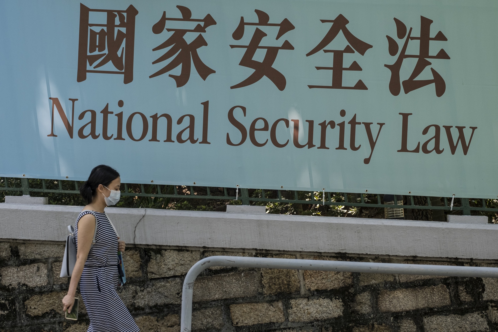 A pedestrian walks past a government-sponsored advertisement promoting China’s planned national security in Hong Kong on June 19.