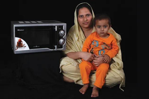 Tahira Bibi and child with her new microwave oven