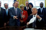 President Donald Trump signs an executive order on March 13, 2017, giving OMB Director Mick Mulvaney a mission: reorganize the executive branch.