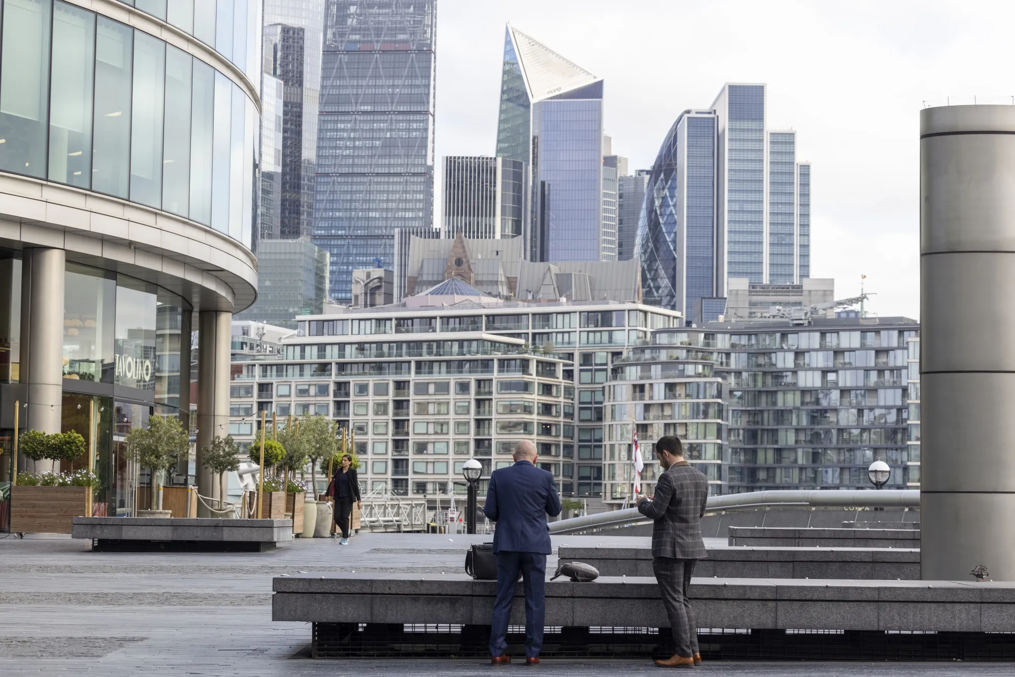 Office workers stand in view of skyscrapers in the City of London.