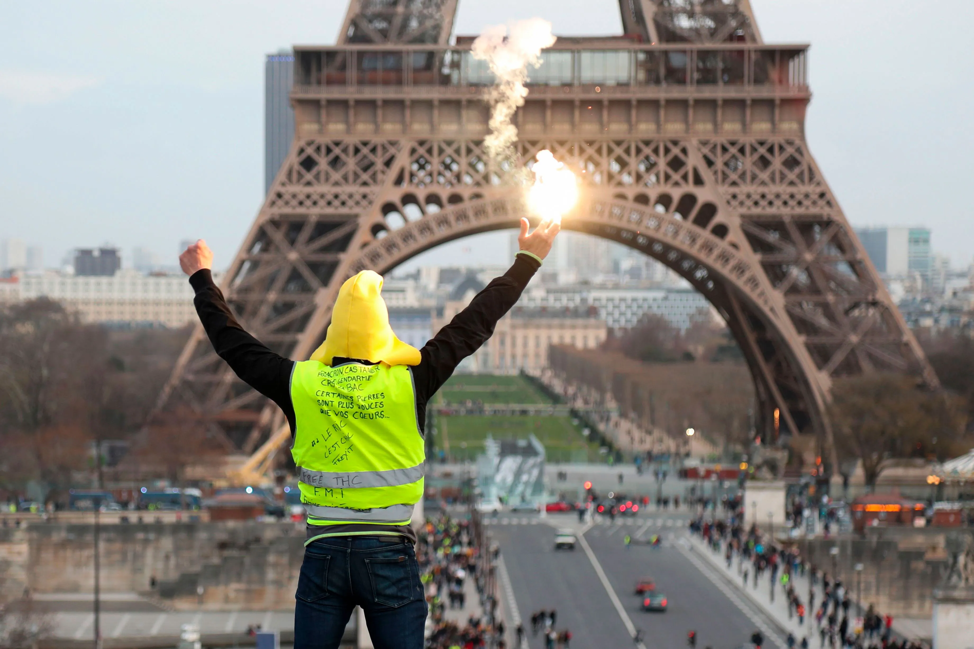 A protester holding a flare faces the Eiffel Tower in Paris on Feb. 9.